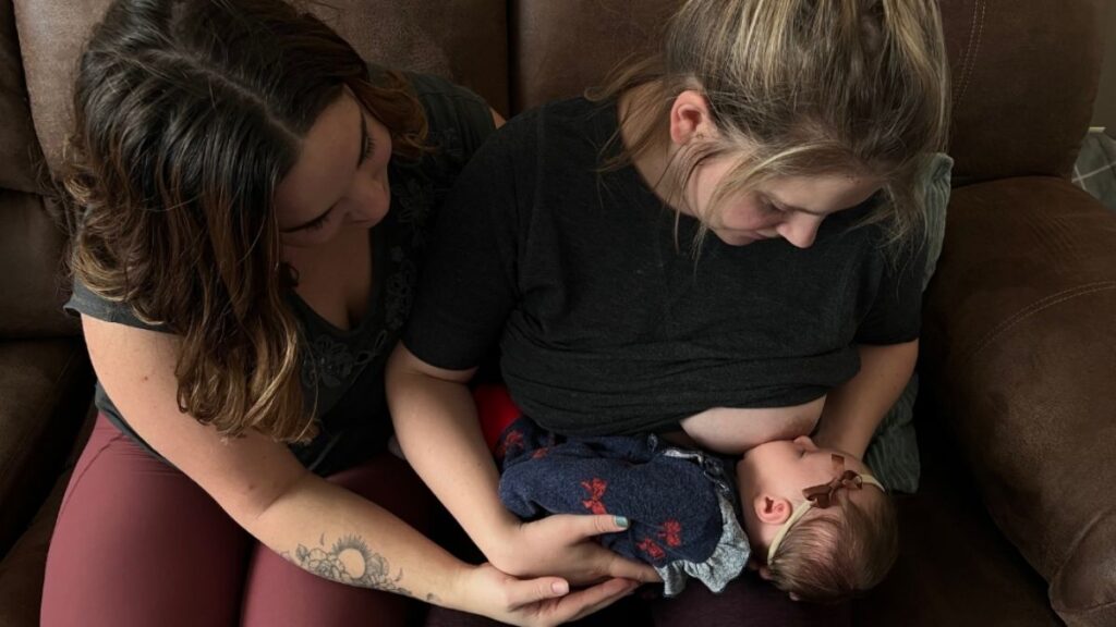 Lactation consultant guiding a new mom in Grande Prairie during an in-home breastfeeding consultation.
